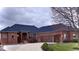 Stately brick home featuring a large driveway and a three-car garage, with a covered front entryway at 5373 Ashby Ct, Greenwood, IN 46143