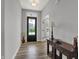 Inviting foyer featuring wood floors, a black front door with glass panes, and a decorative hall table at 5492 Cottage Grove Ln, Noblesville, IN 46062