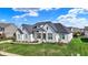 Beautiful home with black roof accents, crisp white siding, a manicured lawn, and beautiful landscaping at 5492 Cottage Grove Ln, Noblesville, IN 46062