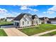 Beautiful home with black roof accents, crisp white siding, a manicured lawn, and an attached two car garage at 5492 Cottage Grove Ln, Noblesville, IN 46062