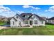 Beautiful home with black roof accents, crisp white siding, a manicured lawn, and beautiful landscaping at 5492 Cottage Grove Ln, Noblesville, IN 46062