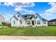 Beautiful home with black roof accents, crisp white siding, a manicured lawn, and beautiful landscaping at 5492 Cottage Grove Ln, Noblesville, IN 46062