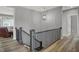 Well-lit hallway featuring wood floors, modern lighting, and elegant railing, creating a welcoming transition at 5492 Cottage Grove Ln, Noblesville, IN 46062