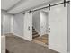 Bright hallway featuring sliding barn doors, leading to carpeted stairs with gray walls at 5492 Cottage Grove Ln, Noblesville, IN 46062