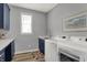 A laundry room with white washer and dryer, and modern blue cabinets at 5492 Cottage Grove Ln, Noblesville, IN 46062
