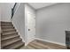 Carpeted staircase with modern wood trim leading to an access door, offers both style and functionality at 5492 Cottage Grove Ln, Noblesville, IN 46062
