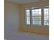 Bright bedroom with a view of a pond visible through large windows, soft carpeting, and natural light at 5639 Aquamarine Dr, Carmel, IN 46033