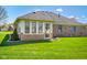 This backyard features a well-maintained lawn and a bright sunroom addition to the home at 5766 Kensington S Way, Plainfield, IN 46168