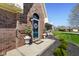 Inviting brick home entrance featuring a beautiful blue front door and manicured landscaping at 5766 Kensington S Way, Plainfield, IN 46168