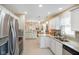 Well-lit kitchen features white cabinets, stainless steel appliances and granite countertops at 5766 Kensington S Way, Plainfield, IN 46168