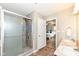 Clean bathroom featuring a glass-enclosed shower and view into the bedroom at 5856 Long Ridge Pl, Indianapolis, IN 46221