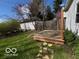 A backyard featuring a wooden deck, green grass, a wooden fence, and a detached garage at 5868 Hillside Ave, Indianapolis, IN 46220