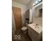 Bright bathroom featuring a pedestal sink, a storage cabinet, and a large mirror at 5868 Hillside Ave, Indianapolis, IN 46220