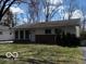Charming single story home with white siding, brick foundation, and mature trees in a suburban setting at 5868 Hillside Ave, Indianapolis, IN 46220