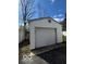 View of a detached garage with a white garage door, next to another garage and driveway at 5868 Hillside Ave, Indianapolis, IN 46220