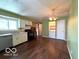 Open concept kitchen with wooden floor, white cabinets, and modern appliances at 5868 Hillside Ave, Indianapolis, IN 46220