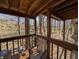 View of a deck with wooden railings, exposed beams, and outdoor seating overlooking a wooded area at 61 Osage Ct, Columbus, IN 47201