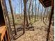 Back of home with view of wooded area and a hillside covered with fallen leaves at 61 Osage Ct, Columbus, IN 47201
