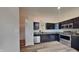 Well-equipped kitchen featuring stainless steel appliances, dark wood cabinetry, granite countertops, and modern lighting fixtures at 6508 Pergola Ln, Indianapolis, IN 46241