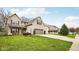 View of the home and its landscaped yard, featuring a two-car garage and driveway at 6526 Angel Falls Dr, Noblesville, IN 46062