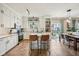 Open kitchen with stainless appliances, white cabinets, tile backsplash, and an island with seating and backyard view at 6526 Angel Falls Dr, Noblesville, IN 46062