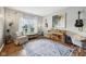 A light-filled office or music room with hardwood floors, a window, a piano, and a comfortable seating area at 6526 Angel Falls Dr, Noblesville, IN 46062