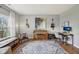 Home office or music room with hardwood floors, vintage piano, guitars, and a well-lit workspace at 6526 Angel Falls Dr, Noblesville, IN 46062
