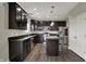 Modern kitchen featuring dark cabinetry, stainless steel appliances, and a center island with bar seating at 6674 Buhrstone Ln, Avon, IN 46123