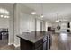 Kitchen with central island, dark wood cabinets, wood flooring, and views through to the living room at 6674 Buhrstone Ln, Avon, IN 46123