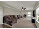 Spacious living room with comfortable seating, ceiling fan, and view of the yard at 6674 Buhrstone Ln, Avon, IN 46123