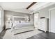 Bright bedroom with a white bed, neutral walls, wood-look floors, a barn door, and matching nightstands at 6707 Meadow View Ct, Avon, IN 46123