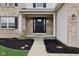 Inviting front entrance with a black front door, landscaping, and porch at 6707 Meadow View Ct, Avon, IN 46123
