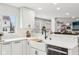 Bright kitchen with a farmhouse sink, stainless steel dishwasher, white countertops and cabinets, and white backsplash at 6707 Meadow View Ct, Avon, IN 46123