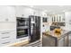 Kitchen with stainless steel appliances, white cabinets and countertops, and wood grain flooring at 6707 Meadow View Ct, Avon, IN 46123