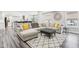 A modern living room with gray wood floors, a sectional sofa, and an area rug at 6707 Meadow View Ct, Avon, IN 46123
