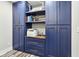 A well-organized storage space features custom blue cabinetry with gold hardware and decorative shelving at 6707 Meadow View Ct, Avon, IN 46123
