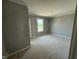 Bedroom featuring light-colored walls, an unfinished floor, a window, and a door at 7308 Broadview Ln, McCordsville, IN 46055