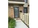 Brick townhouse entrance featuring a gray door, mailbox, and light fixture at 7411 Country Brook Dr, Indianapolis, IN 46260