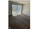 Living room with neutral carpeting and a large sliding glass door to the outside at 7411 Country Brook Dr, Indianapolis, IN 46260