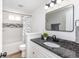 Modern bathroom featuring granite countertops, a stylish mirror, and a shower with decorative tile accents at 7624 Snowflake Dr, Indianapolis, IN 46227