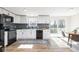 Bright kitchen featuring white cabinets, modern black appliances, and a stylish blue backsplash at 7624 Snowflake Dr, Indianapolis, IN 46227