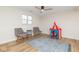 Playful living room featuring hard wood floors, white walls, and large bright window at 7624 Snowflake Dr, Indianapolis, IN 46227
