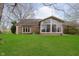 Beautiful backyard with a brick patio, screened-in porch, and lush green lawn at 8535 Olde Mill Circle West Dr, Indianapolis, IN 46260
