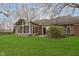 Spacious backyard featuring a well-manicured lawn, brick exterior, and screened-in porch at 8535 Olde Mill Circle West Dr, Indianapolis, IN 46260