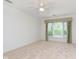 Bright bedroom featuring neutral carpet, a ceiling fan, and a large window with decorative curtains at 8535 Olde Mill Circle West Dr, Indianapolis, IN 46260