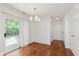 Sunlit dining area with sliding glass door, hardwood floors, and stylish lighting at 8535 Olde Mill Circle West Dr, Indianapolis, IN 46260