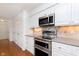 Modern kitchen features stainless steel oven, tile backsplash, and white cabinets at 8535 Olde Mill Circle West Dr, Indianapolis, IN 46260