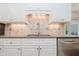 Kitchen with bright backsplash, stainless steel appliances, and white cabinets for ample storage at 8535 Olde Mill Circle West Dr, Indianapolis, IN 46260