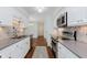 The bright kitchen features white cabinets, stainless appliances and stylish backsplash at 8535 Olde Mill Circle West Dr, Indianapolis, IN 46260