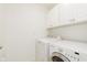 Functional laundry room with modern washer, dryer, and overhead cabinets for storage at 8535 Olde Mill Circle West Dr, Indianapolis, IN 46260